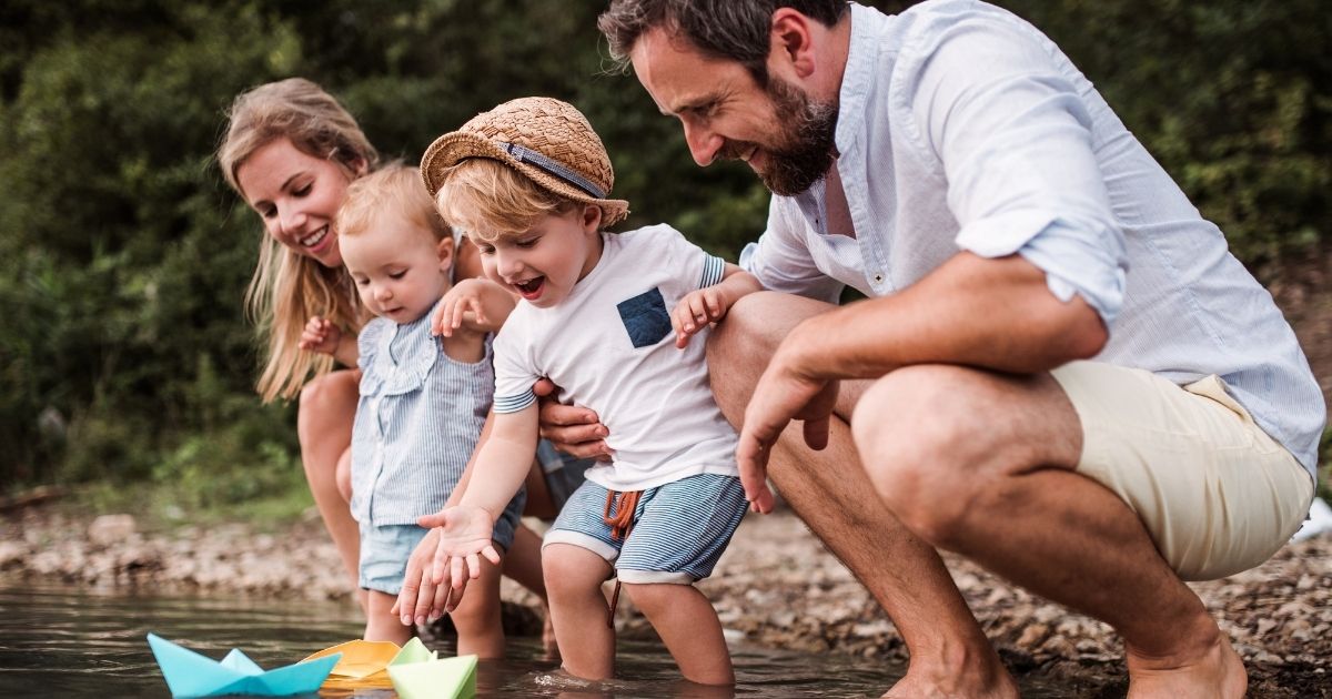 Family playing with children by river